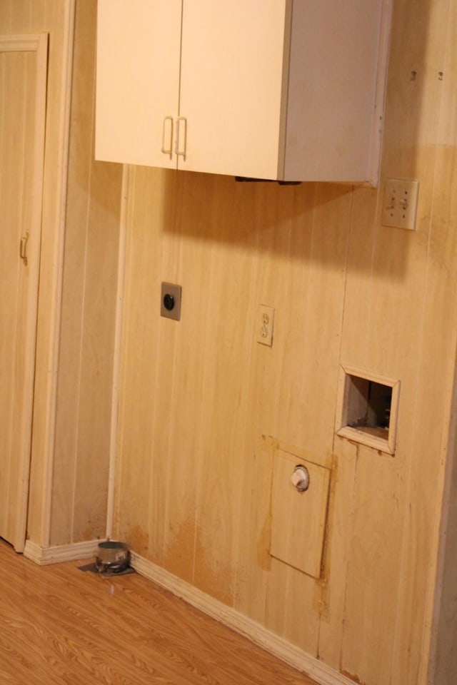 washroom featuring cabinets, hookup for an electric dryer, and light hardwood / wood-style flooring