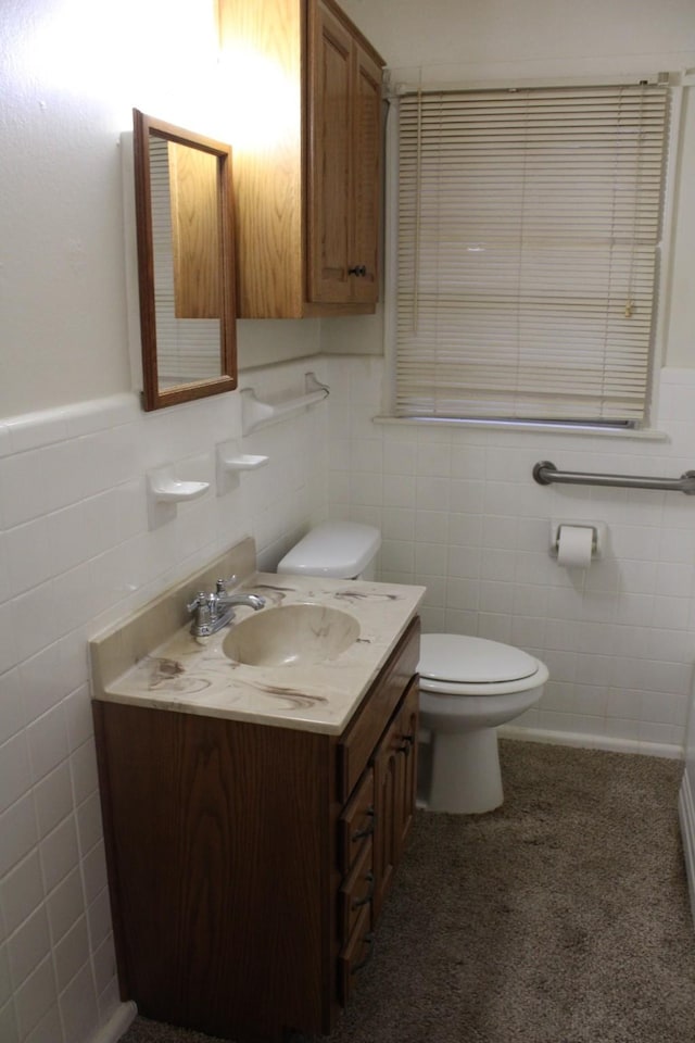 bathroom featuring vanity, tile walls, and toilet