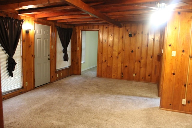 basement featuring light colored carpet and wood walls