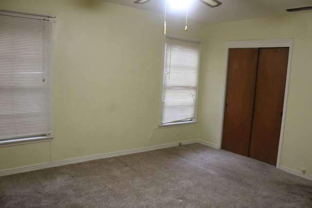 unfurnished bedroom with ceiling fan, carpet floors, and a closet