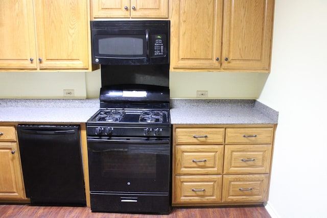 kitchen featuring dark hardwood / wood-style floors and black appliances