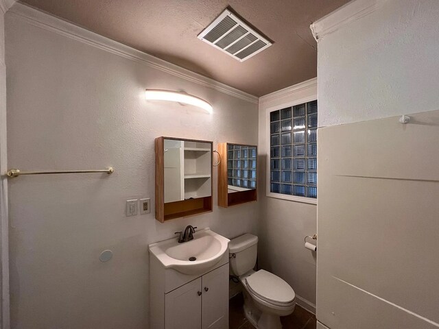 bathroom with vanity, toilet, and ornamental molding