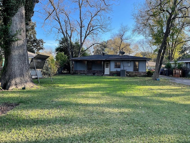 view of front of property with a front lawn and central air condition unit