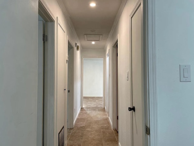 hallway with tile patterned flooring and crown molding