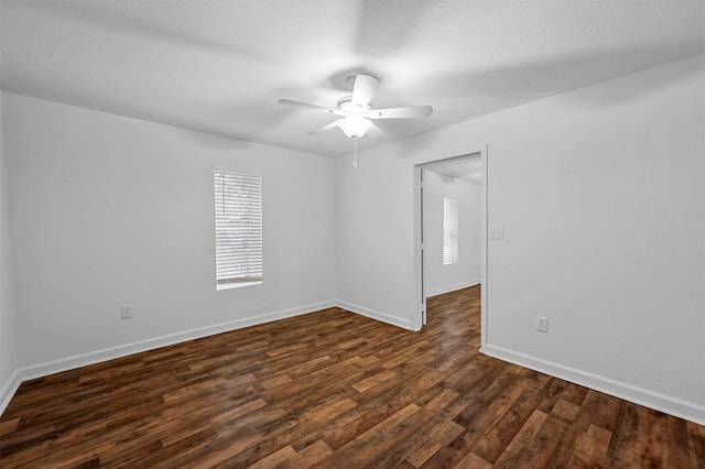 empty room with dark hardwood / wood-style flooring and ceiling fan