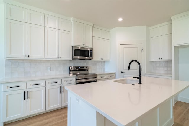 kitchen with a center island with sink and appliances with stainless steel finishes