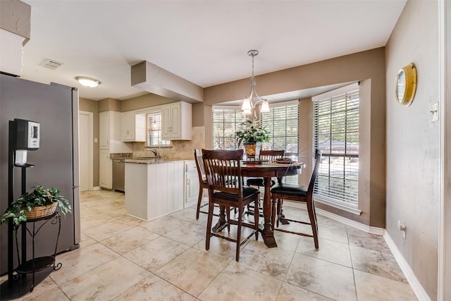 dining room featuring a chandelier and sink