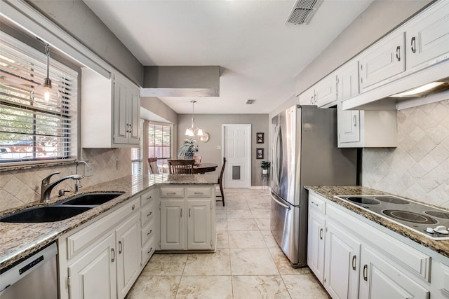 kitchen featuring white cabinetry, sink, a healthy amount of sunlight, stainless steel appliances, and kitchen peninsula