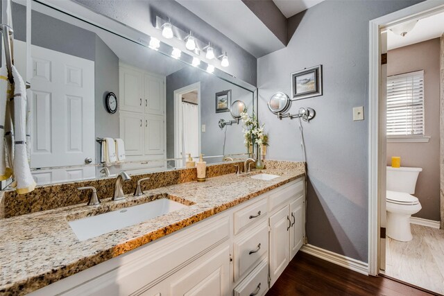 bathroom featuring hardwood / wood-style floors, vanity, and toilet