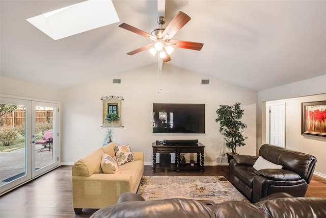 living room with french doors, dark hardwood / wood-style flooring, ceiling fan, and vaulted ceiling with skylight