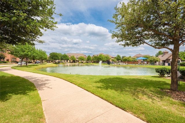 view of home's community with a water view and a lawn