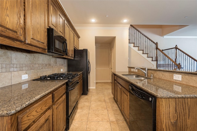 kitchen featuring sink, dark stone countertops, tasteful backsplash, ornamental molding, and black appliances