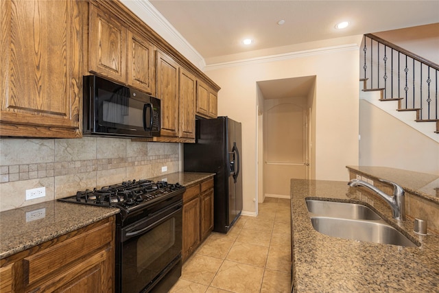 kitchen featuring sink, crown molding, backsplash, black appliances, and dark stone counters