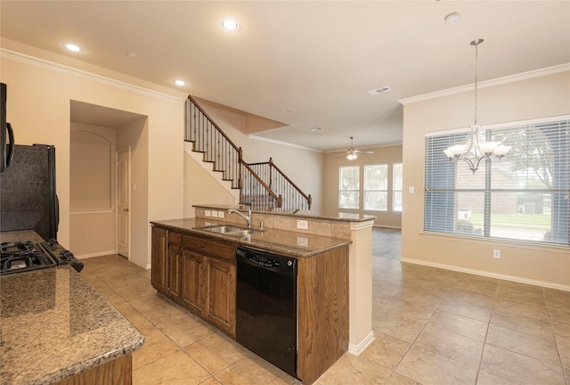 kitchen with sink, light stone counters, a center island with sink, pendant lighting, and black appliances