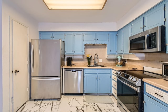 kitchen featuring stainless steel appliances, tasteful backsplash, sink, and blue cabinets