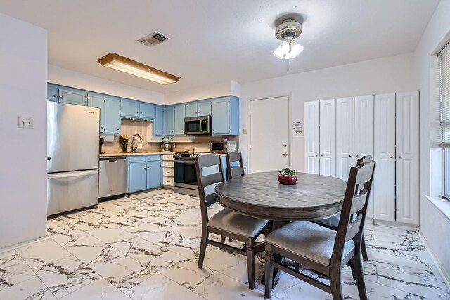 kitchen with sink, stainless steel appliances, and blue cabinets