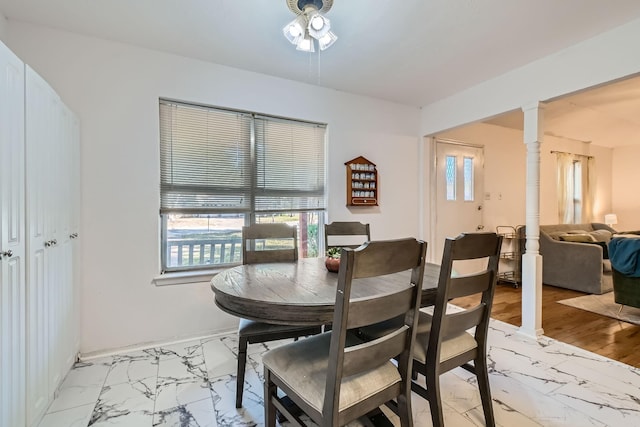 dining room with decorative columns, a healthy amount of sunlight, and light hardwood / wood-style floors