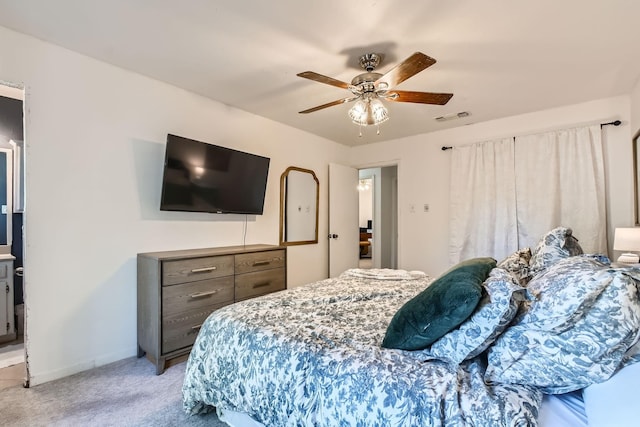 bedroom featuring ceiling fan, ensuite bathroom, and light carpet