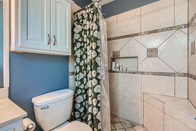 bathroom featuring vanity, toilet, and walk in shower