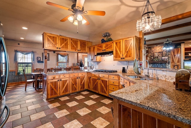 kitchen featuring decorative light fixtures, tasteful backsplash, sink, ceiling fan, and kitchen peninsula