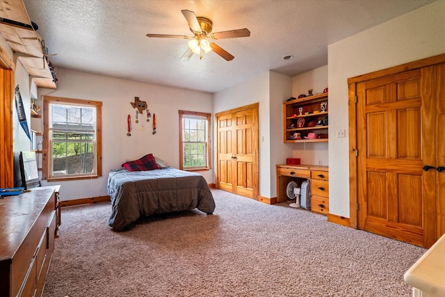 bedroom featuring dark carpet, multiple windows, and a textured ceiling