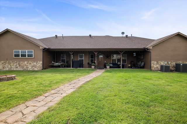 back of property with cooling unit and a yard