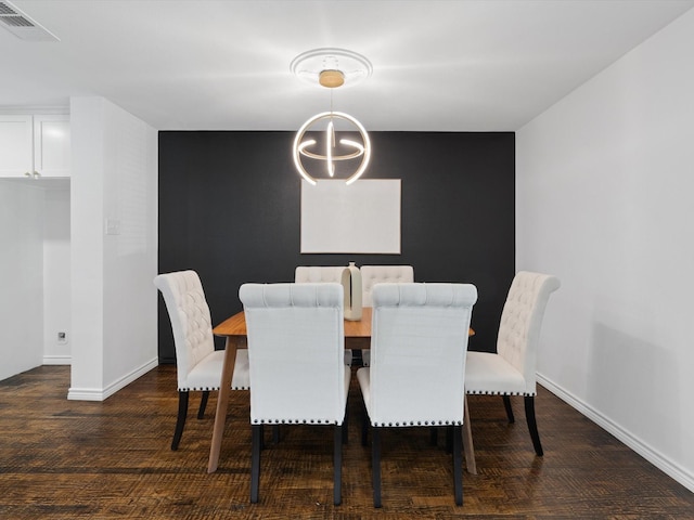 dining room with dark wood-type flooring and an inviting chandelier