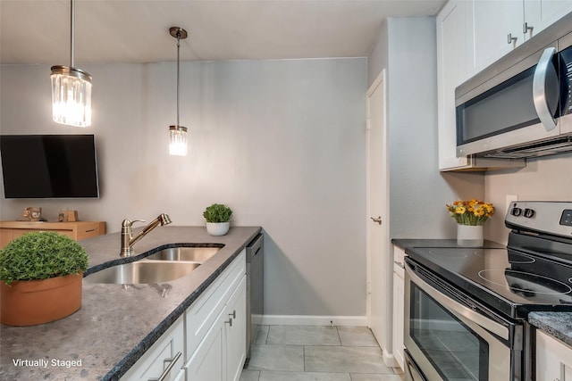 kitchen with appliances with stainless steel finishes, sink, and white cabinets