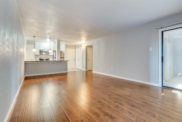 unfurnished living room with dark wood-type flooring