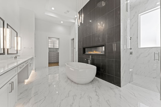 bathroom featuring vanity, independent shower and bath, tile walls, and a tile fireplace