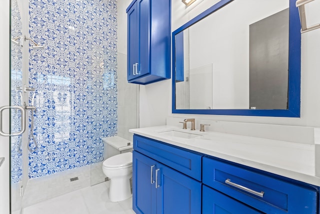 bathroom with tile patterned floors, vanity, toilet, and walk in shower