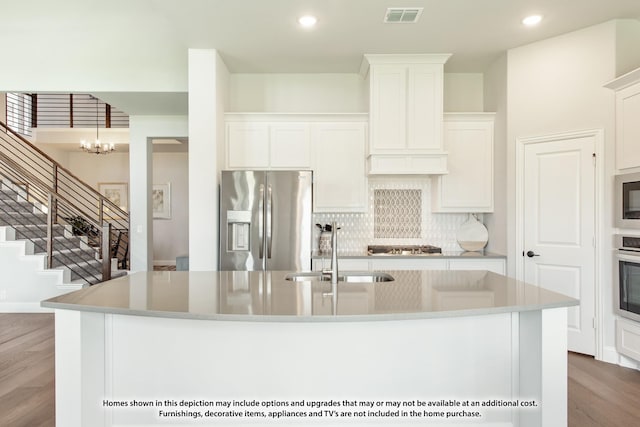 kitchen featuring appliances with stainless steel finishes, sink, a center island with sink, and white cabinets