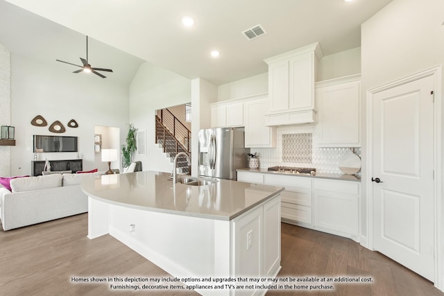 kitchen with white cabinetry, sink, stainless steel appliances, a center island with sink, and light wood-type flooring