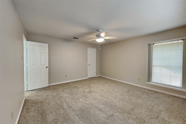 spare room with carpet flooring, ceiling fan, and a textured ceiling