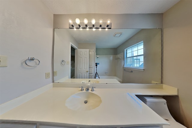 bathroom featuring a textured ceiling and sink