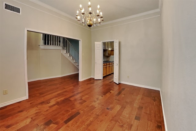 spare room with crown molding, a chandelier, and hardwood / wood-style floors