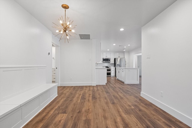 unfurnished living room featuring dark hardwood / wood-style floors, sink, and a chandelier