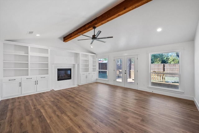 unfurnished living room with vaulted ceiling with beams, dark wood-type flooring, a high end fireplace, and french doors