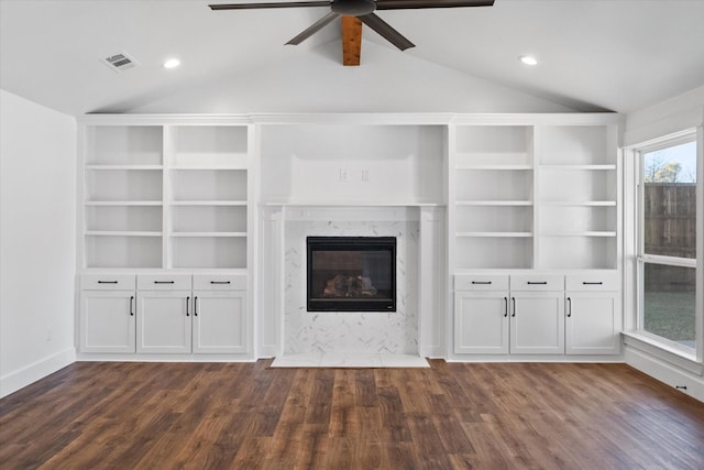 unfurnished living room with dark wood-type flooring, vaulted ceiling, and a premium fireplace