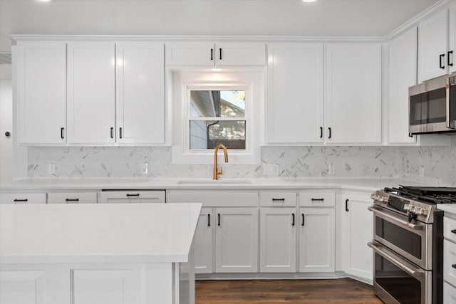 kitchen featuring sink, dark wood-type flooring, appliances with stainless steel finishes, white cabinetry, and decorative backsplash