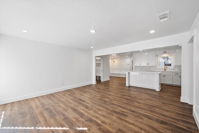 unfurnished living room with sink and dark hardwood / wood-style floors