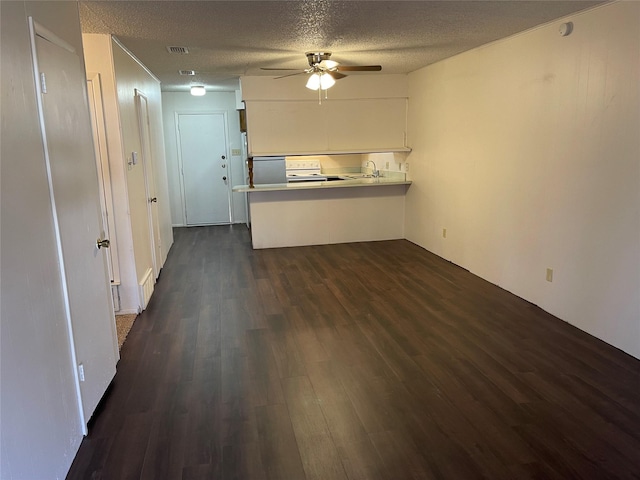 unfurnished living room featuring a textured ceiling, dark hardwood / wood-style flooring, ceiling fan, and sink