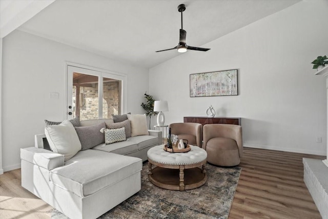 living room featuring ceiling fan, wood-type flooring, and vaulted ceiling