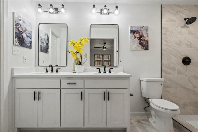 bathroom with a tile shower, ceiling fan, vanity, and toilet