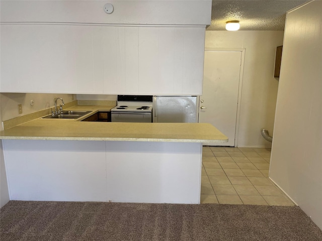 kitchen with kitchen peninsula, light tile patterned floors, electric range, stainless steel refrigerator, and sink