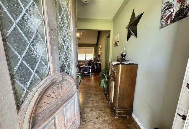 corridor with crown molding and dark wood-type flooring