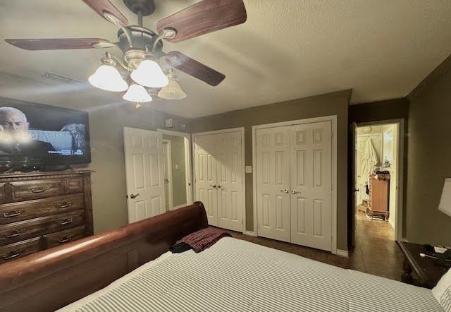 bedroom with multiple closets and ceiling fan