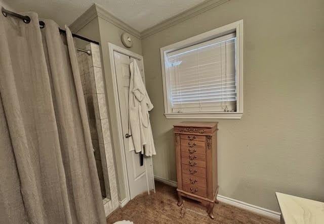 bathroom with a shower with curtain and ornamental molding