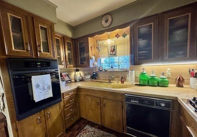 kitchen with backsplash, sink, black appliances, and dark hardwood / wood-style floors