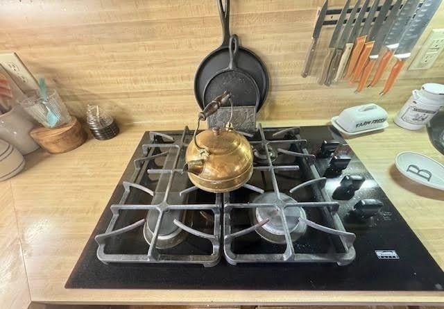 room details with black gas cooktop and wooden walls